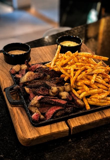 Tábua de carne fatiada com batata frita na chapa de ferro